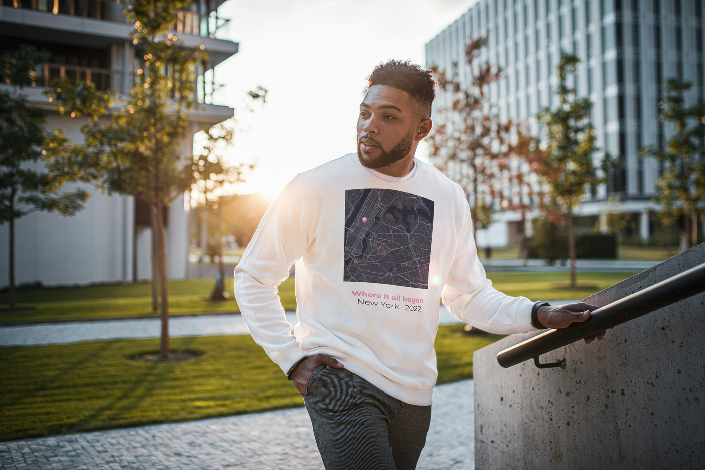 Man wearing a white sweatshirt showing custom city map with heart pin